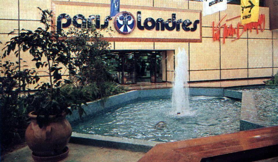 Exterior of a París-Londres department store. A mall water fountain and a large potted plant are near the entrance