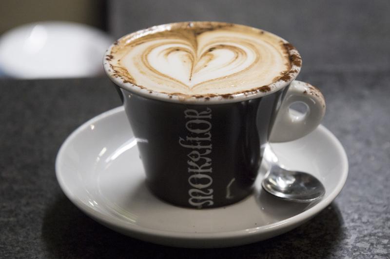A coffee with foam in the shape of a heart
