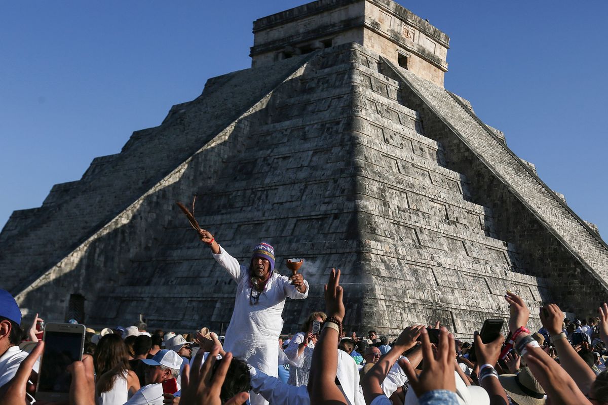 People surround the Kukulcan Pyramid as a shaman performs a spring equinox ritual at the Mayan archaeological site of Chichen Itza