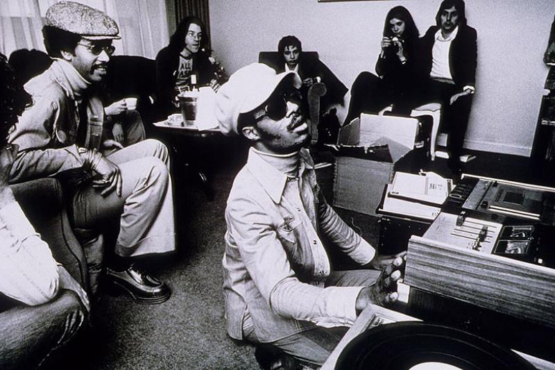Stevie Wonder puts on a cassette for friends backstage
