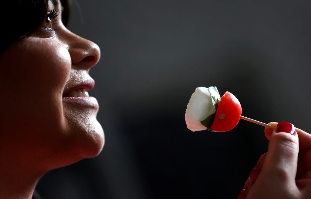 Marketing Executive Alexandra Munday prepares to eat mozzarella cheese with tomato