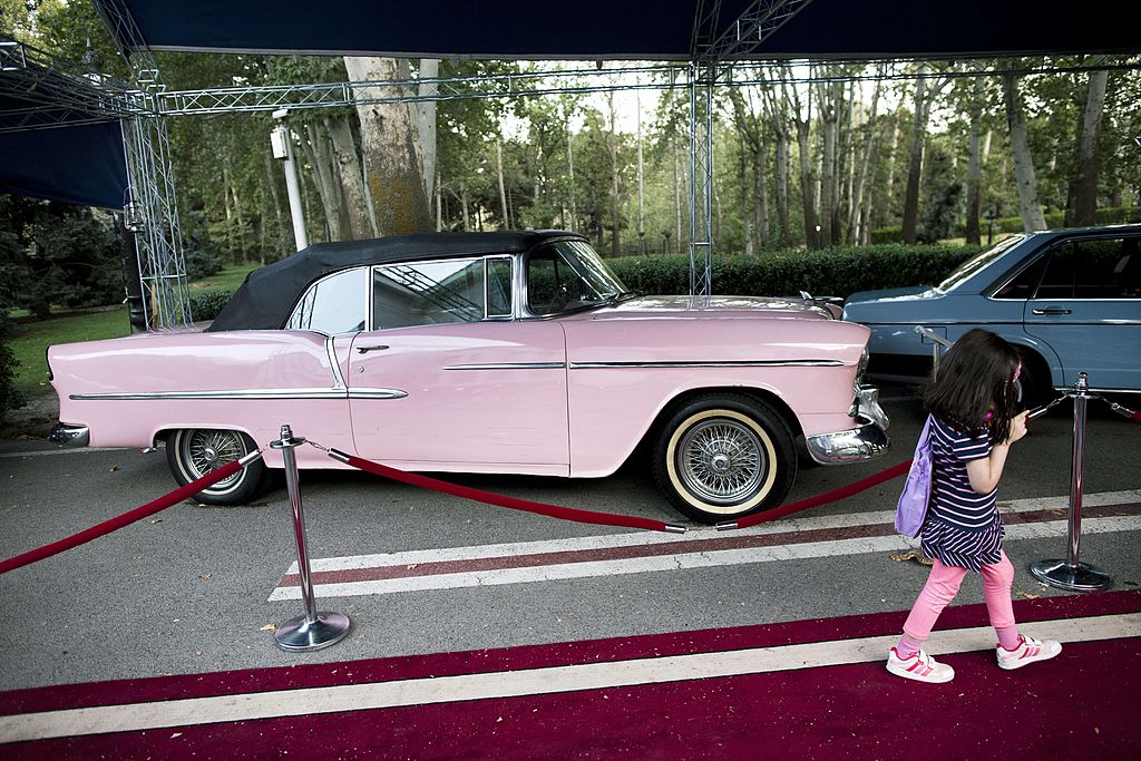 girl walks past a 1955 American Chevrolet 
