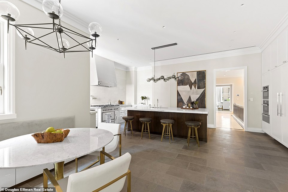 From this angle, we can see an eating area in front of the kitchen, and a doorway leading to the hallway and further rooms beyond the kitchen.