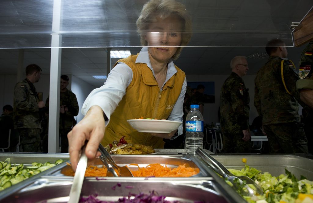 a woman putting together a salad at a salad bar