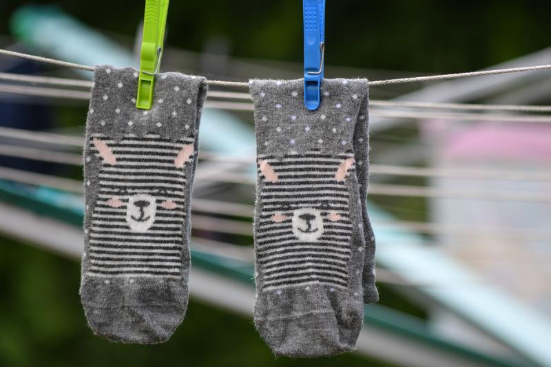 Freshly washed lama socks of a child hang on a clothes horse 