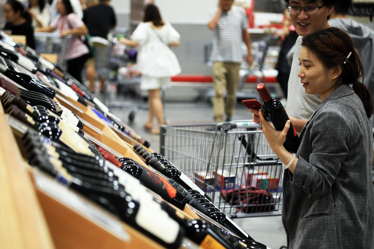 Customers look at bottles of red wine at Costco's first outlet in China 