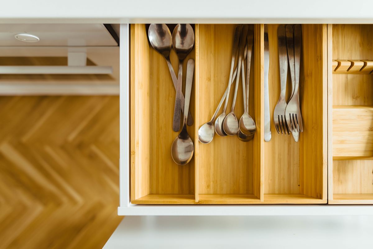 Silverware rests in a wooden drawer