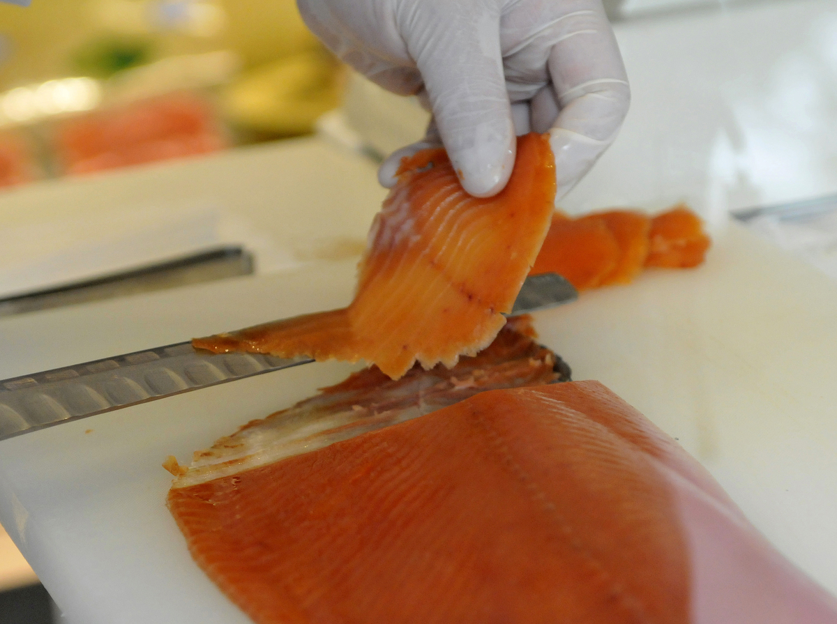 A chef slices raw salmon at a shop in Tokyo.