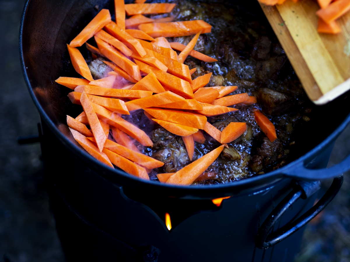 Chopped carrots are added to a lamb strew.