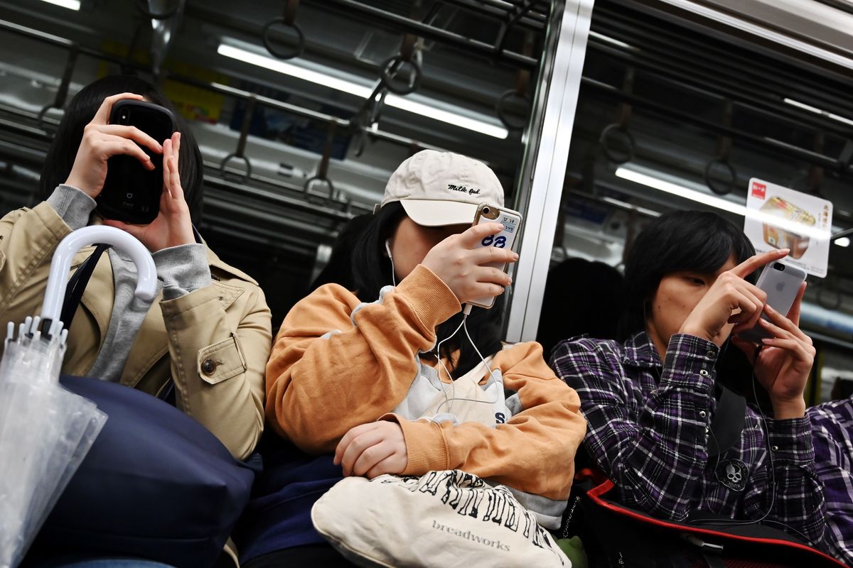 People browse their smartphones in a metro train in Tokyo.