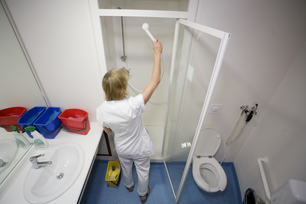 A worker cleans the shower at the Maternity of Saint Vincent De Paul Hospital.