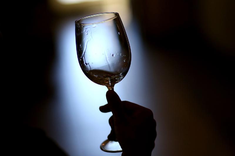 A visitor holds a glass while tasting at Madonna Estate.