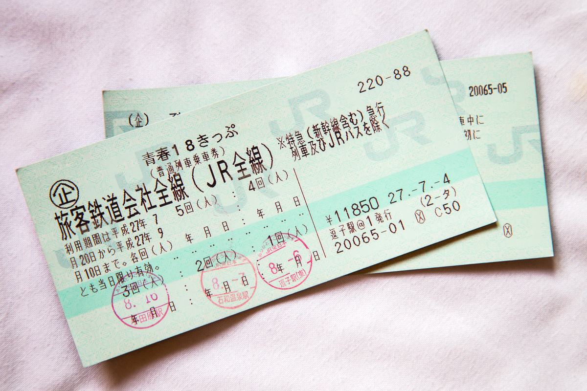 The Seishun 18 Ticket, a popular JR Japan Railway, sits on a light pink blanket.