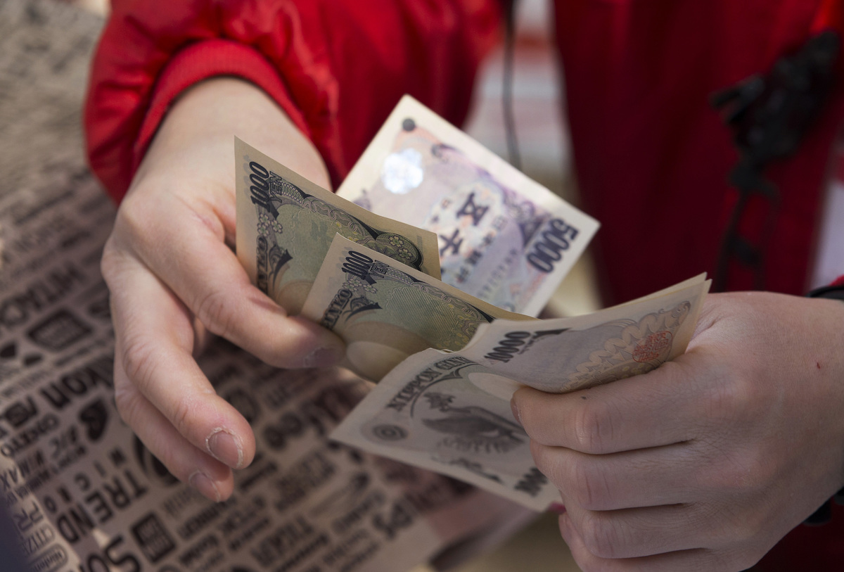 An employee counts Japanese yen notes as he sells a 'lucky bag'.