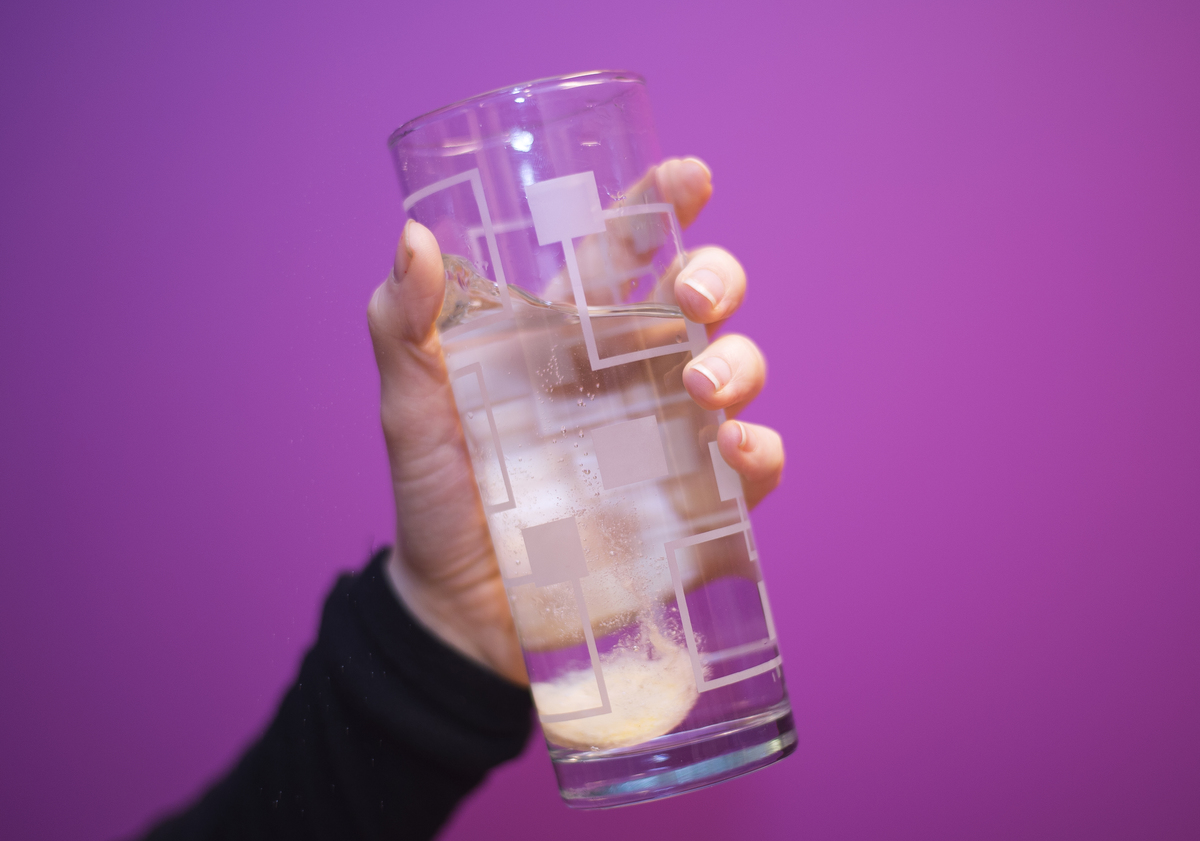 A vitamin C tablet dissolves into sparkling water.