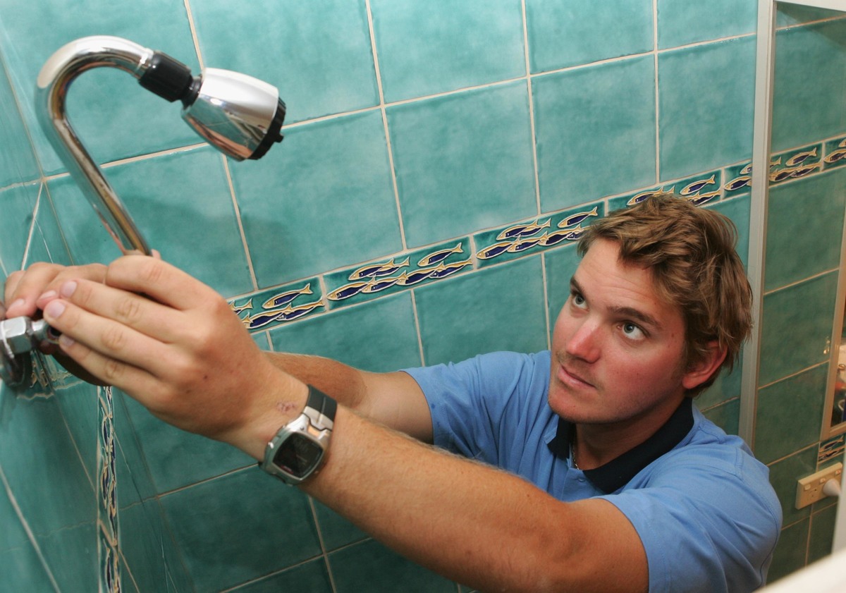  A tradesman intalls a water saving showerhead.