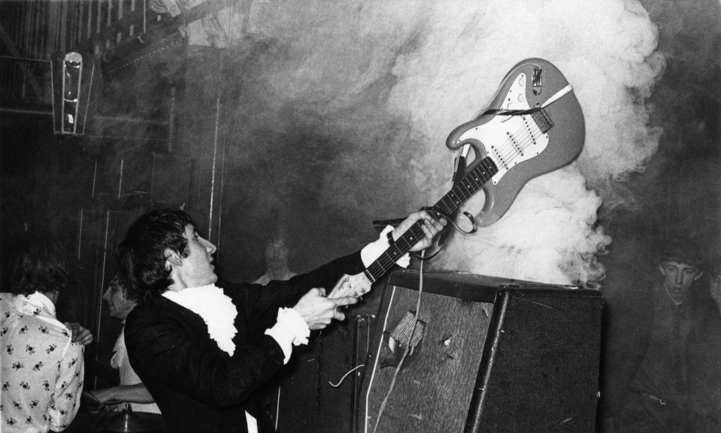 Townshend destroying his guitar on an amplifier 