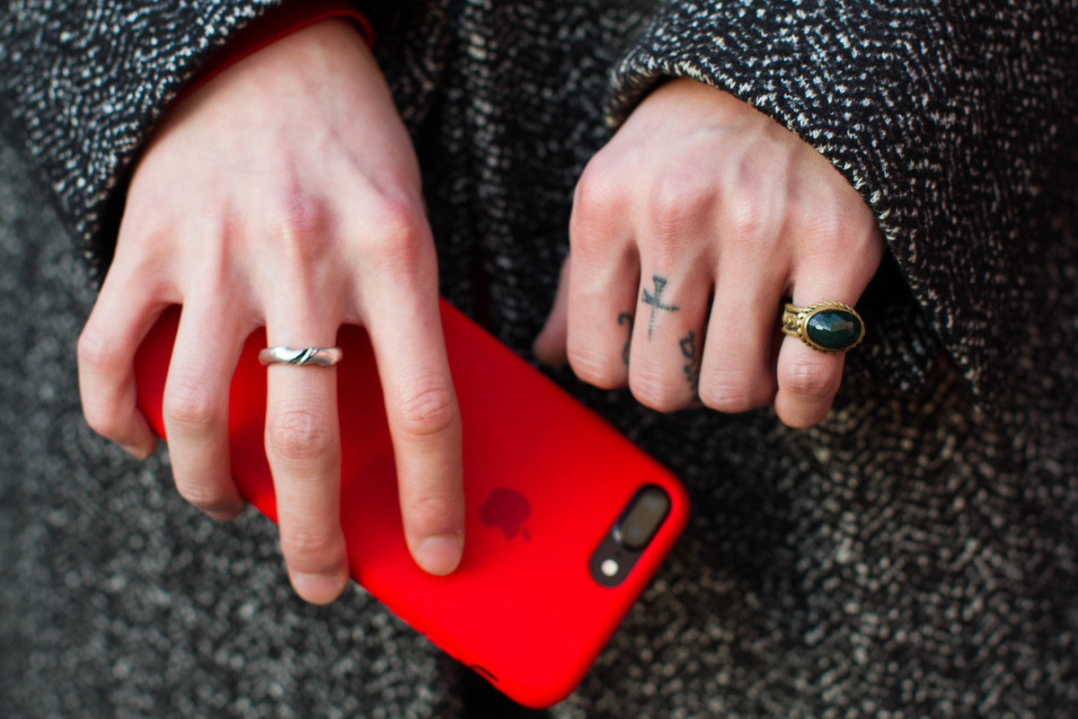 Woman holds her phones with finger tattoos on her hands in Tokyo, Japan.