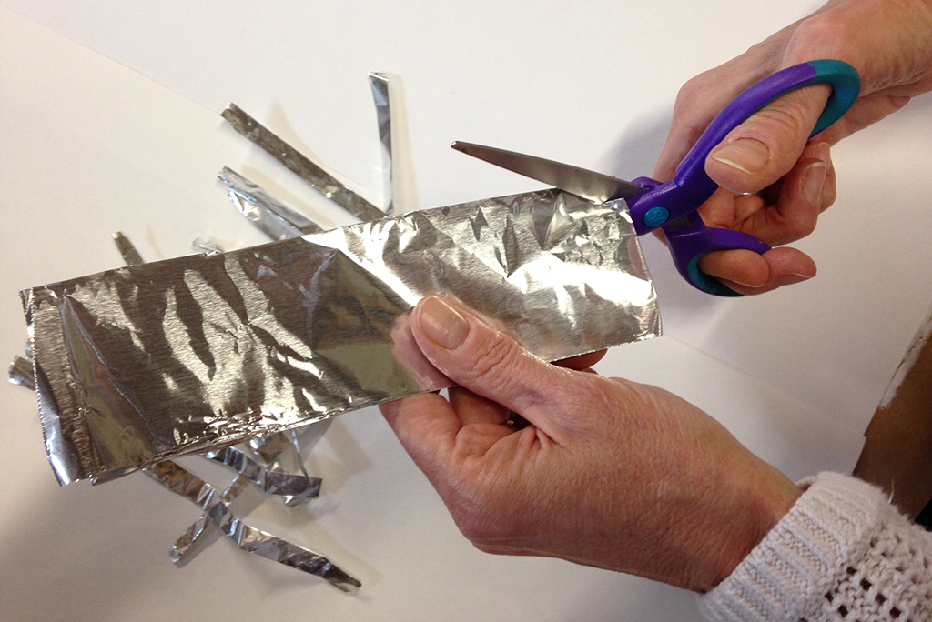 Cutting aluminum foil with scissors 