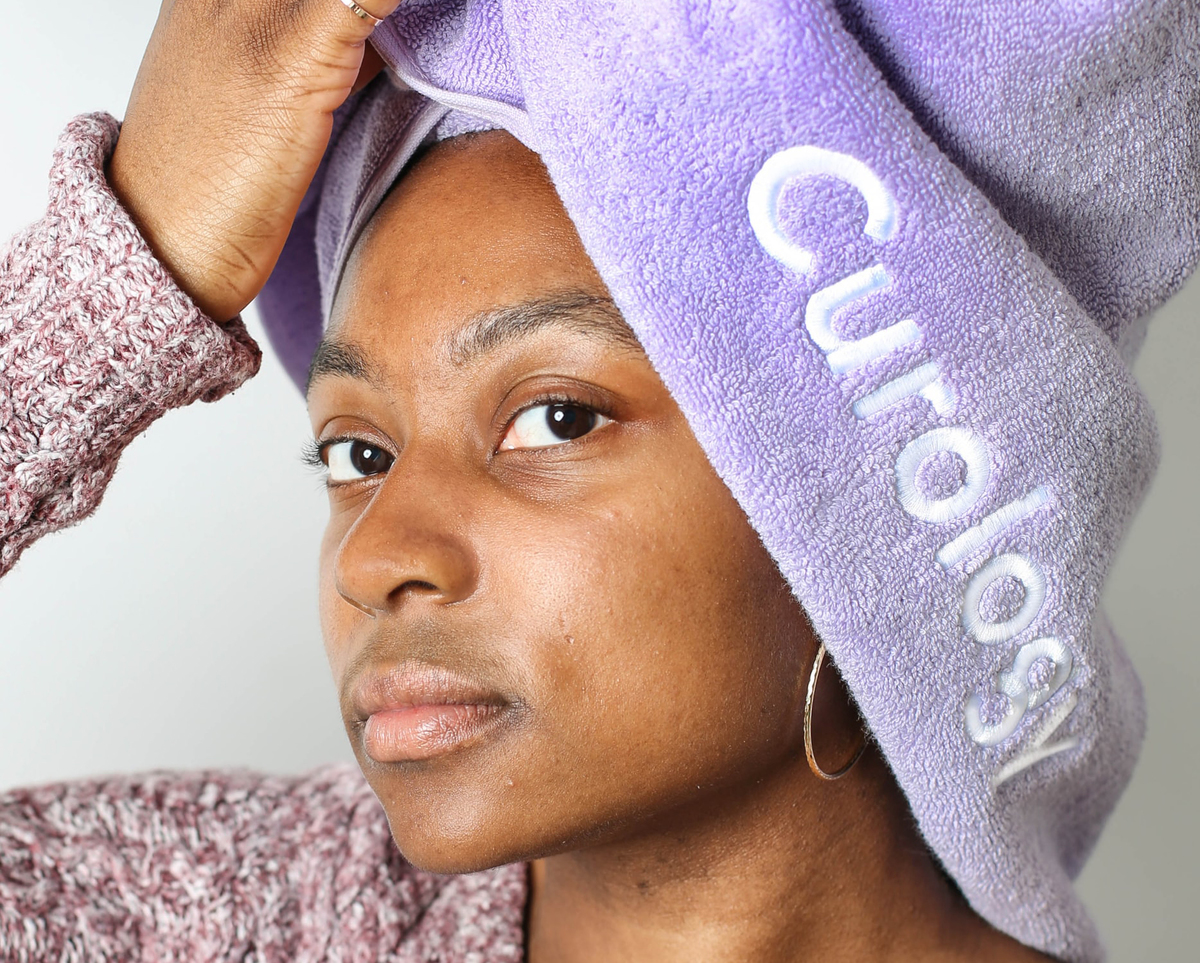 Woman has her hair wrapped in a shower towel.