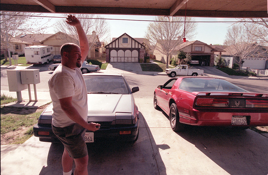 A man stands before his opened garage.