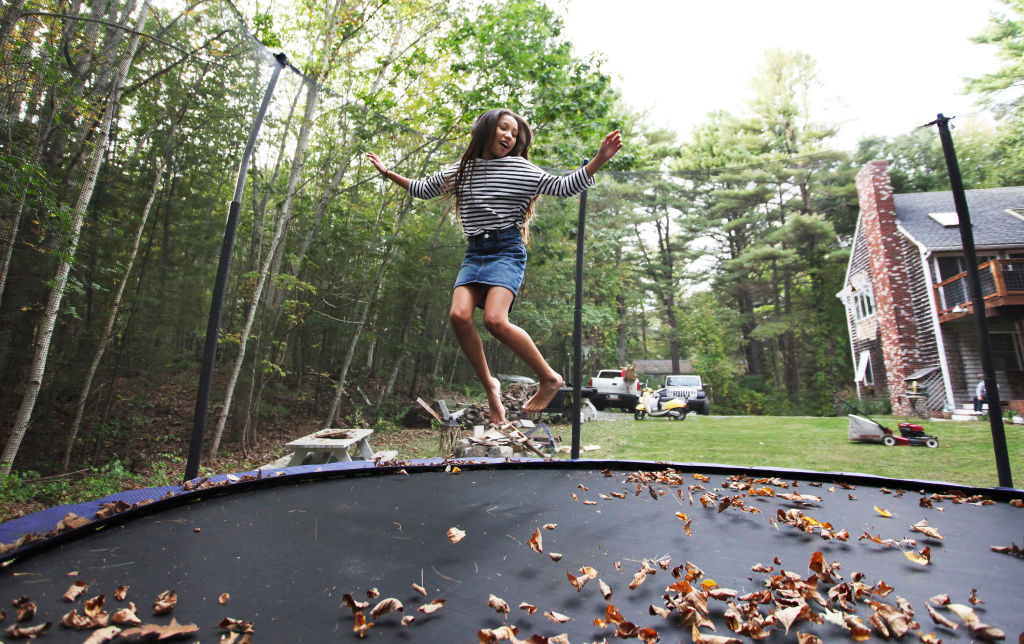 A girl jumps on a trampoline.