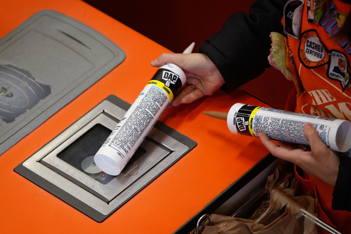 An employee scans items as customers buy goods at a Home Depot.
