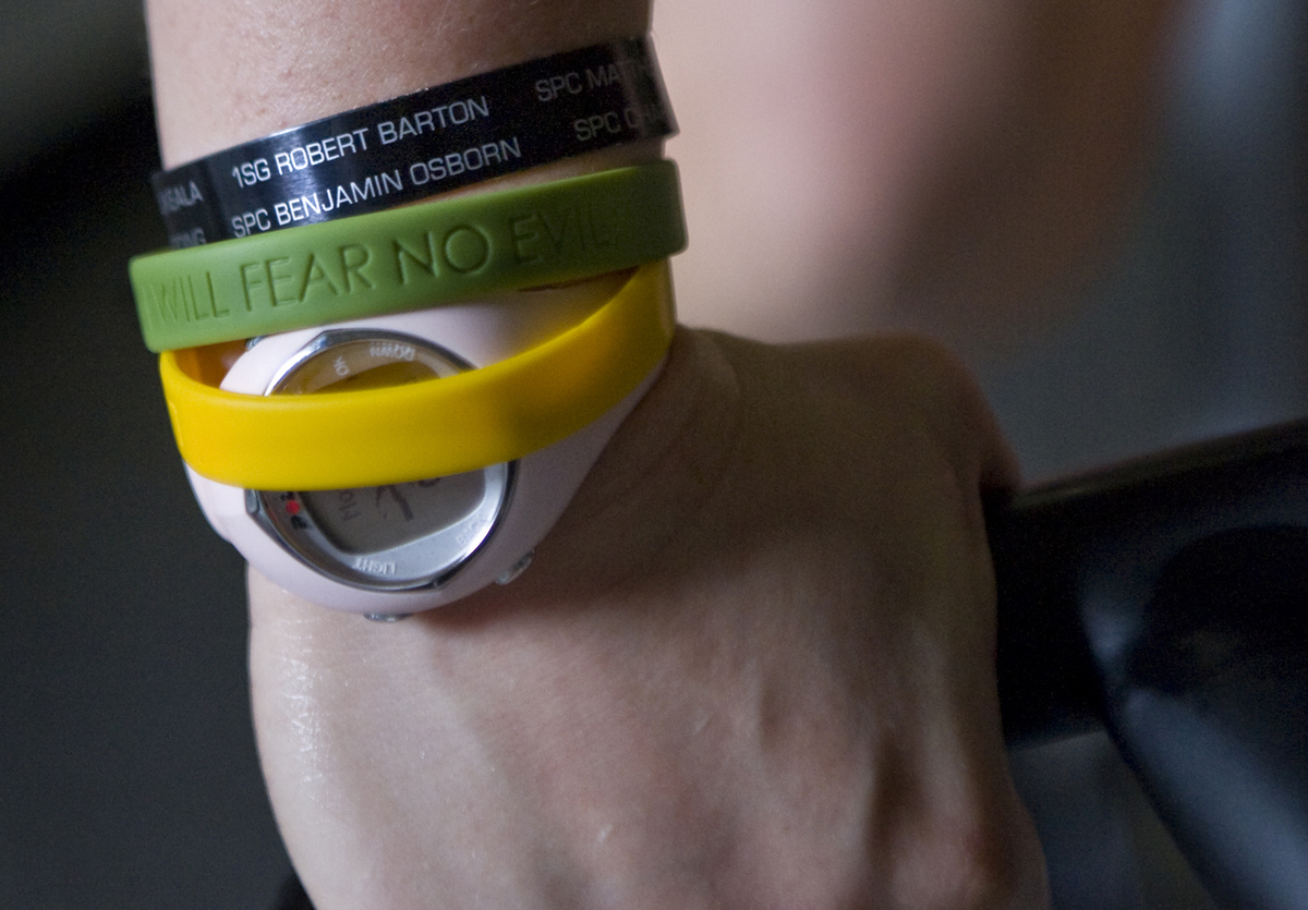A woman wears rubber bracelets over a watch.
