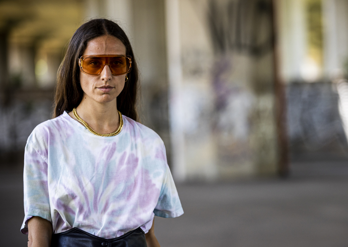 A woman wears a tie dye t-shirt.