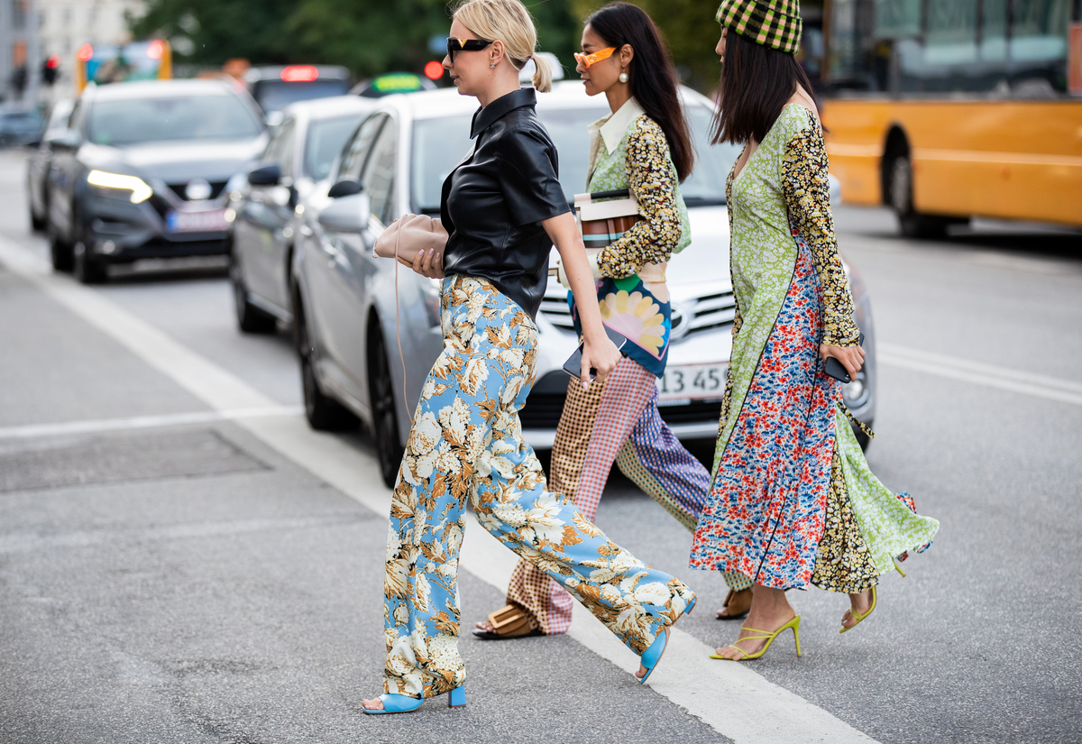 Guests of Copenhagen Fashion Week cross the street in clothes with mismatched patterns.