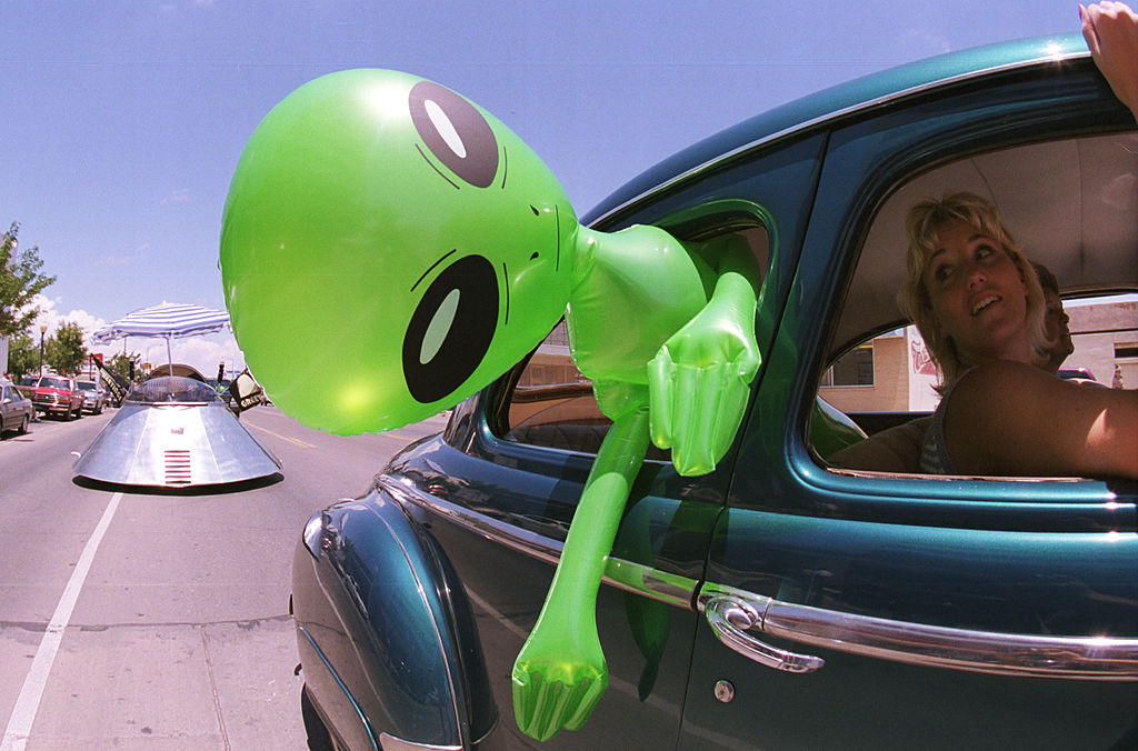 a woman driving with an inflatable alien in roswell, new mexico