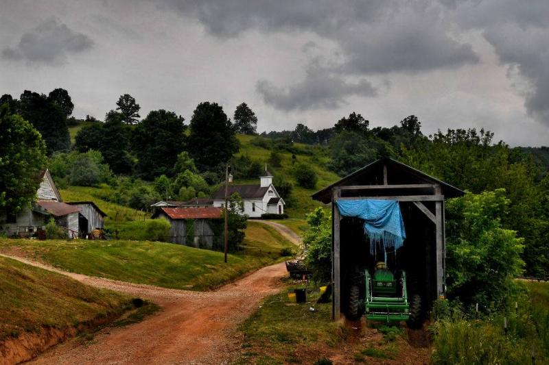 A farm and an old country church share a dirt road