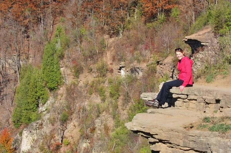 A woman sits on the cliff.