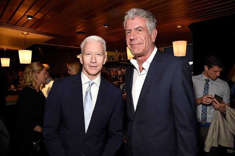 anthony bourdain and cooper posing for a photo
