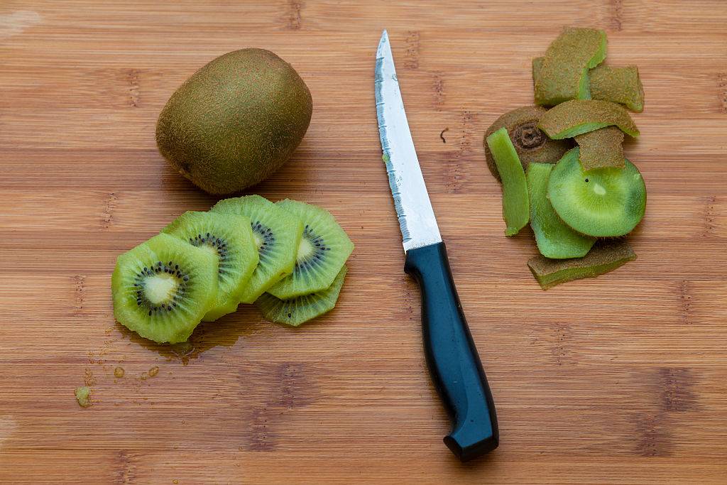 Kiwifruit on a wooden chopping board with a knife
