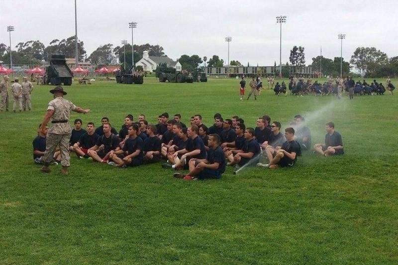 boy sitting in direct line of sprinkler