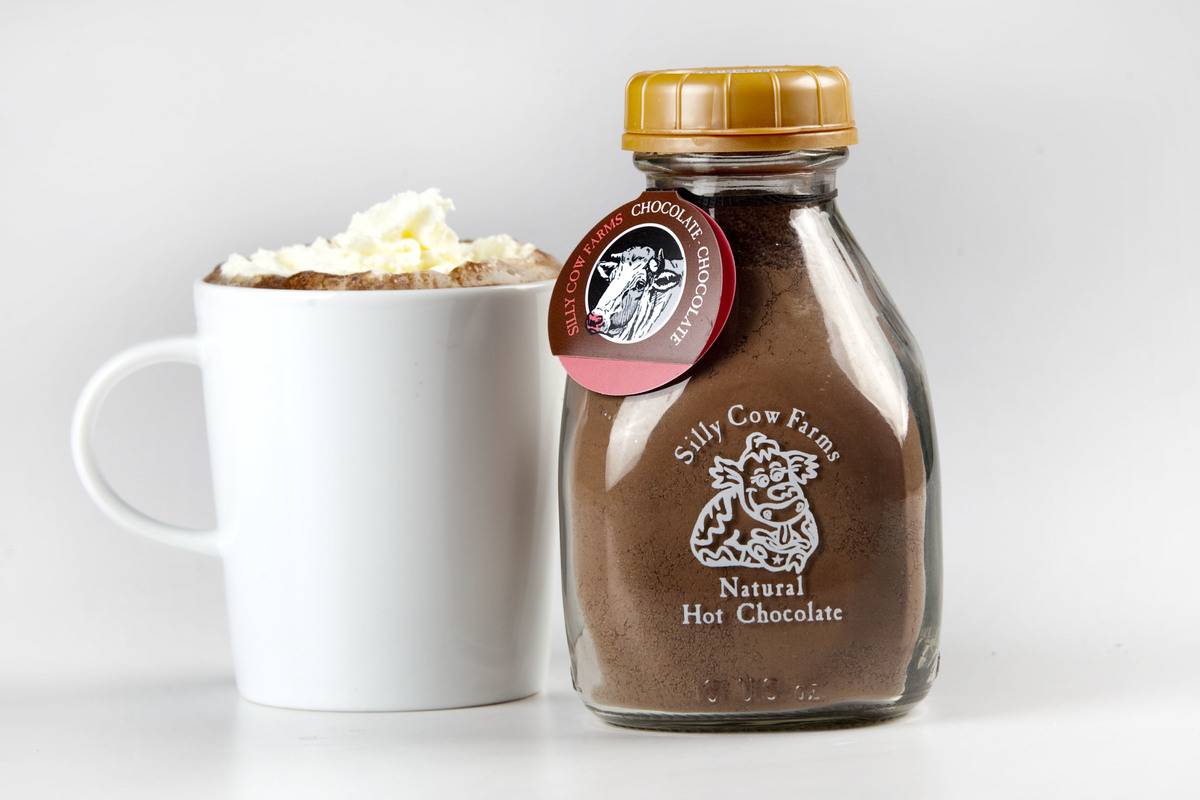 A cup of hot chocolate sits next to the chocolate mixture.