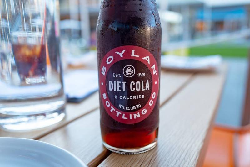 A bottle of diet cola sits on a restaurant table.
