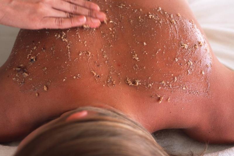 A woman receives a massage with an exfoliating body scrub.