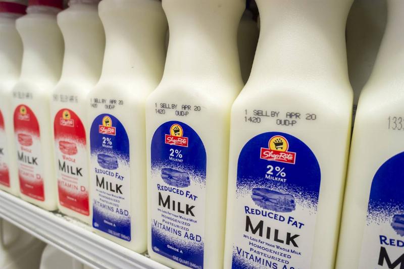 Reduced fat milk cartons are stacked on a grocery store shelf.