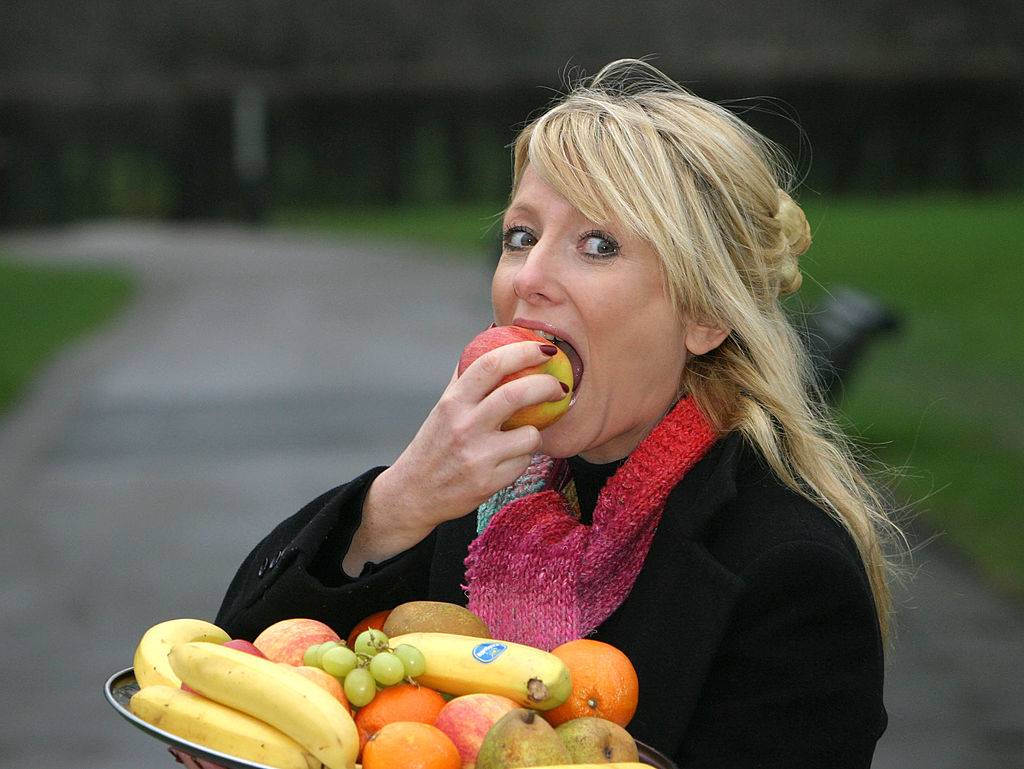 a woman taking a bite out of an apple