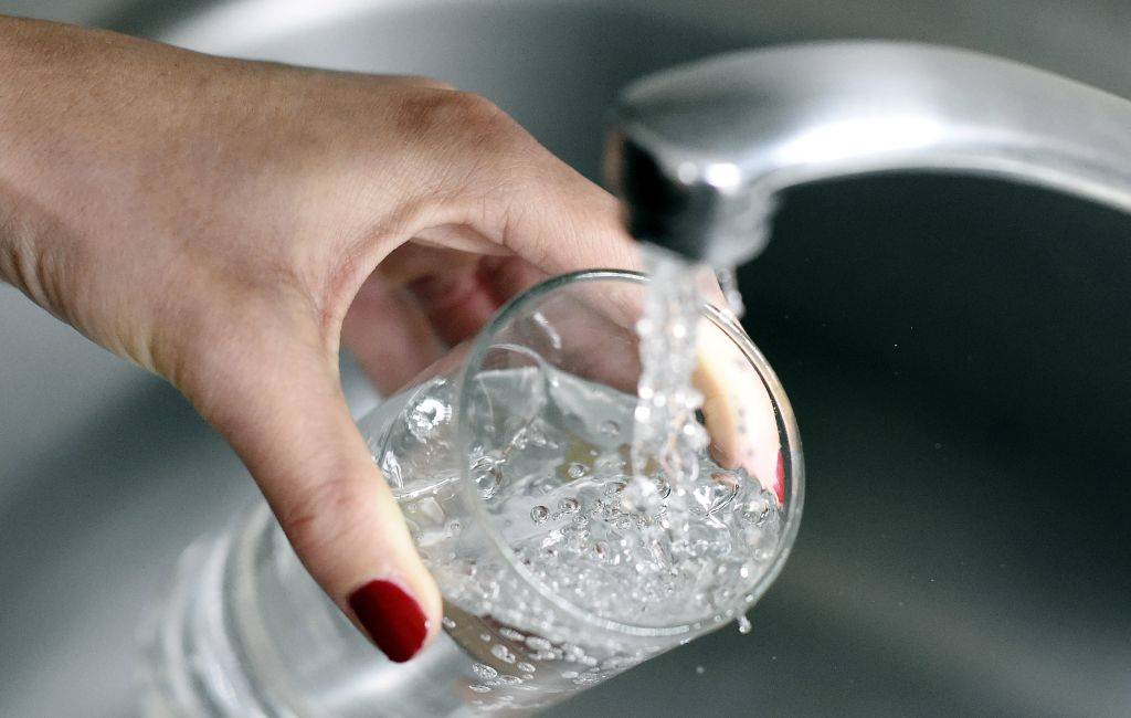 A woman fills up a glass with water