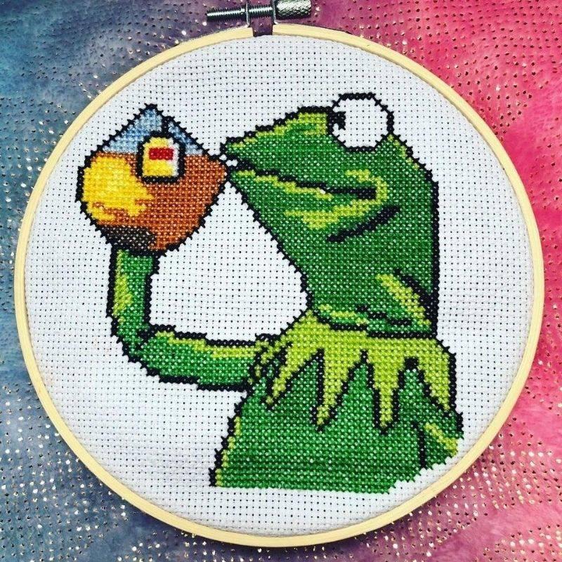 a cross stitch of kermit the frog drinking the tea