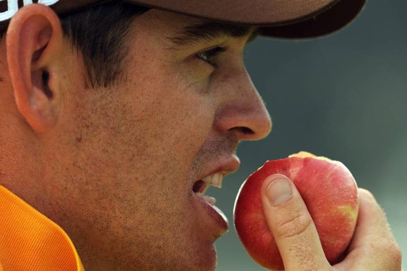 A man takes a bite of an apple.