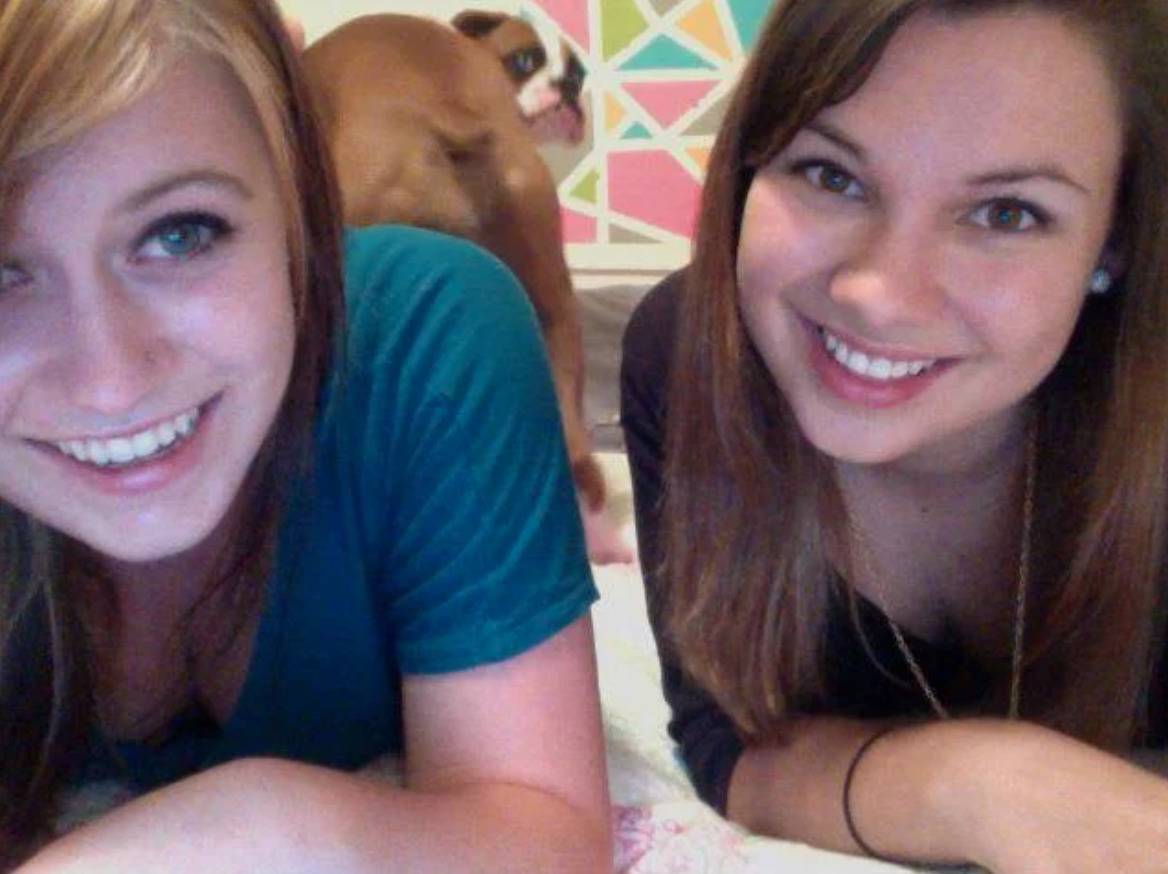 selfie of two girls has dog's butt in the background