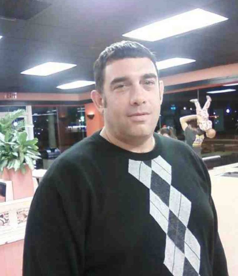 baby nearly being tossed over a head in background of selfie