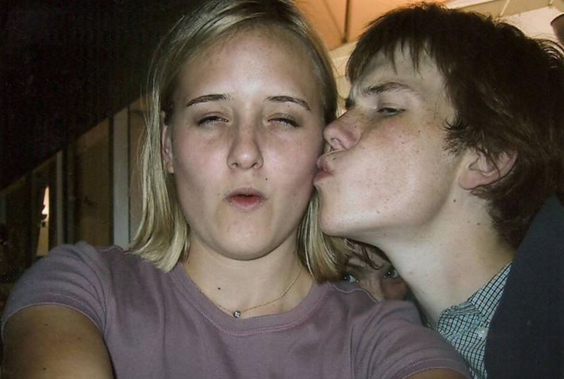 photo of boy kissing girl's cheek with someone elses eyes peaking through