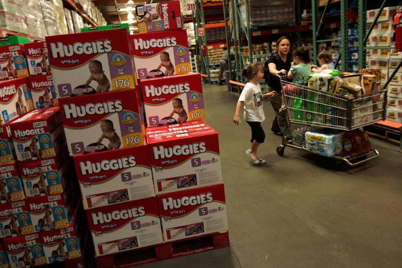 A family passes by bulk packages of diapers at a Costco store