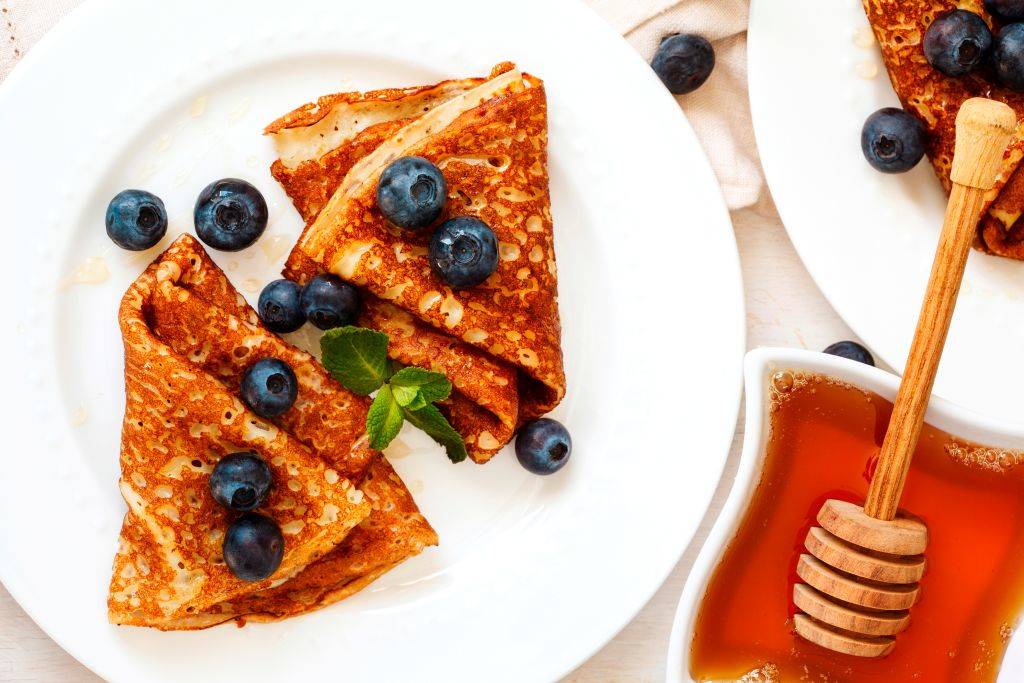 Homemade crepes with fresh blueberries and honey. 