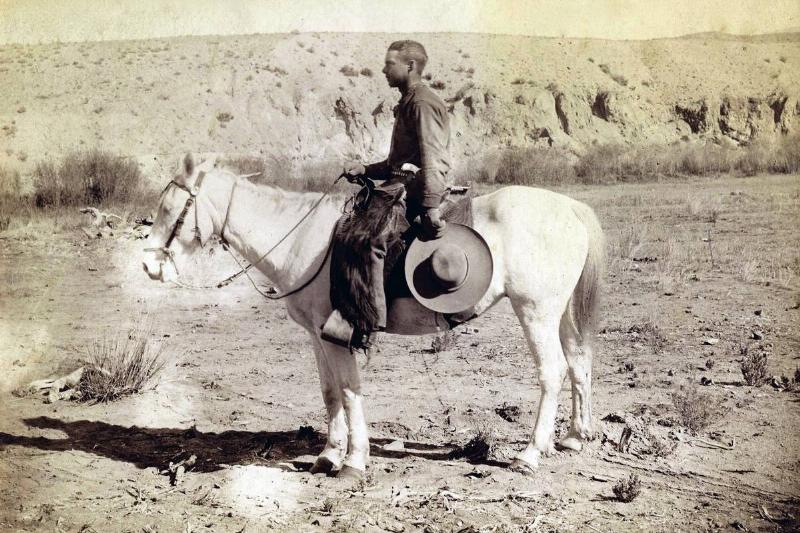 A southwestern cowboy sits on a horse in 1878.
